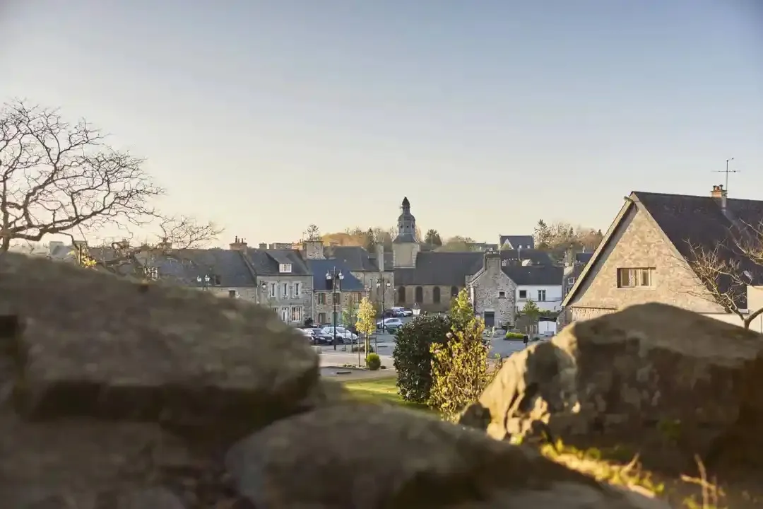 Vue de Châtelaudren-Plouagat au coucher du soleil, avec le clocher et les toits d’ardoise.
